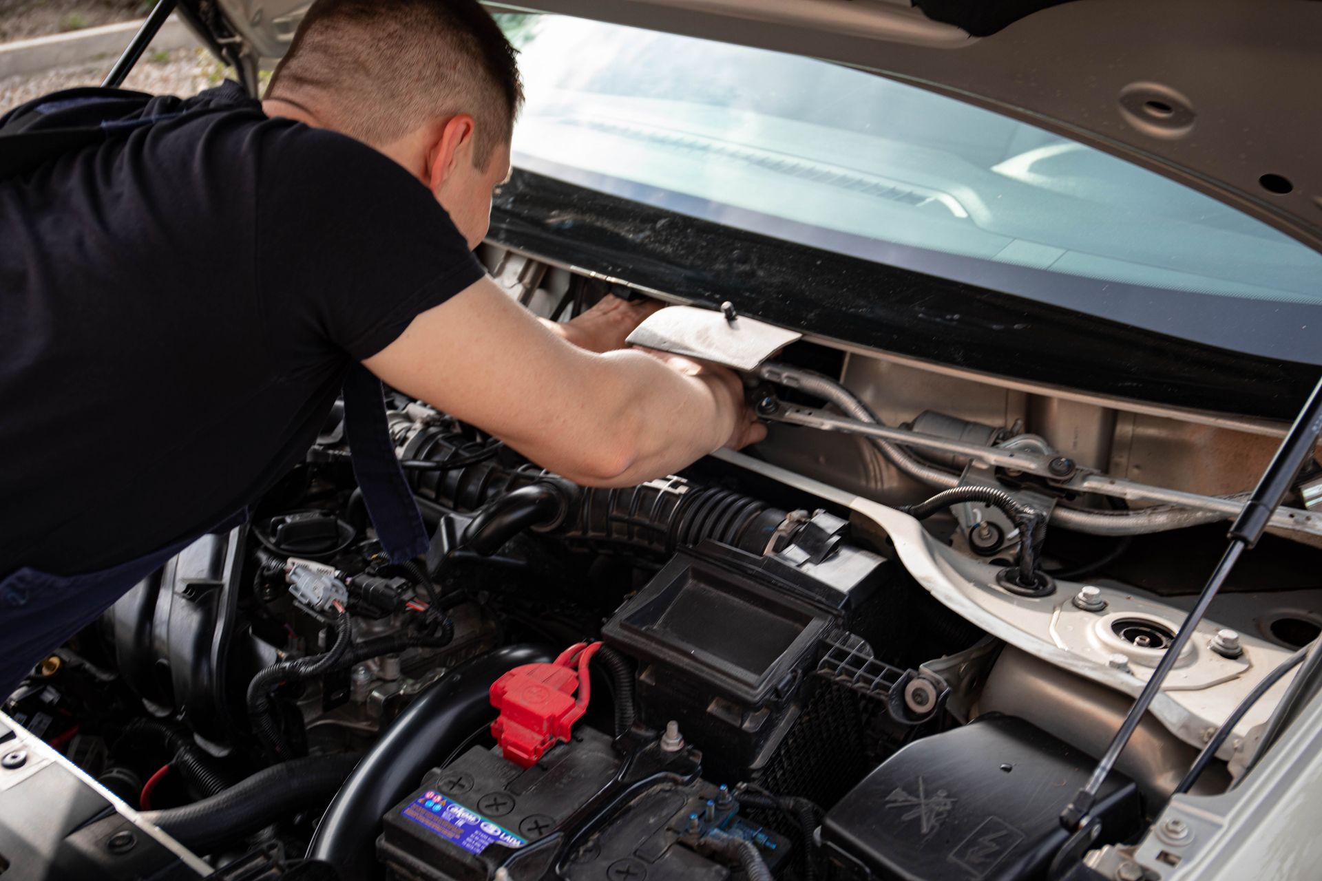 Mechanic inspecting a car raised on a lift in a repair shop
